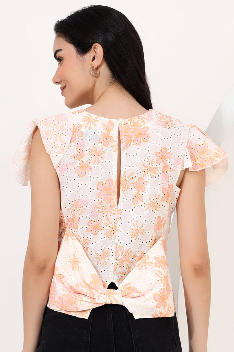 Woman wearing a floral top with a plain background