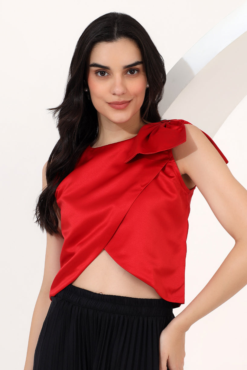 Woman wearing a red top with a bow detail on a white background