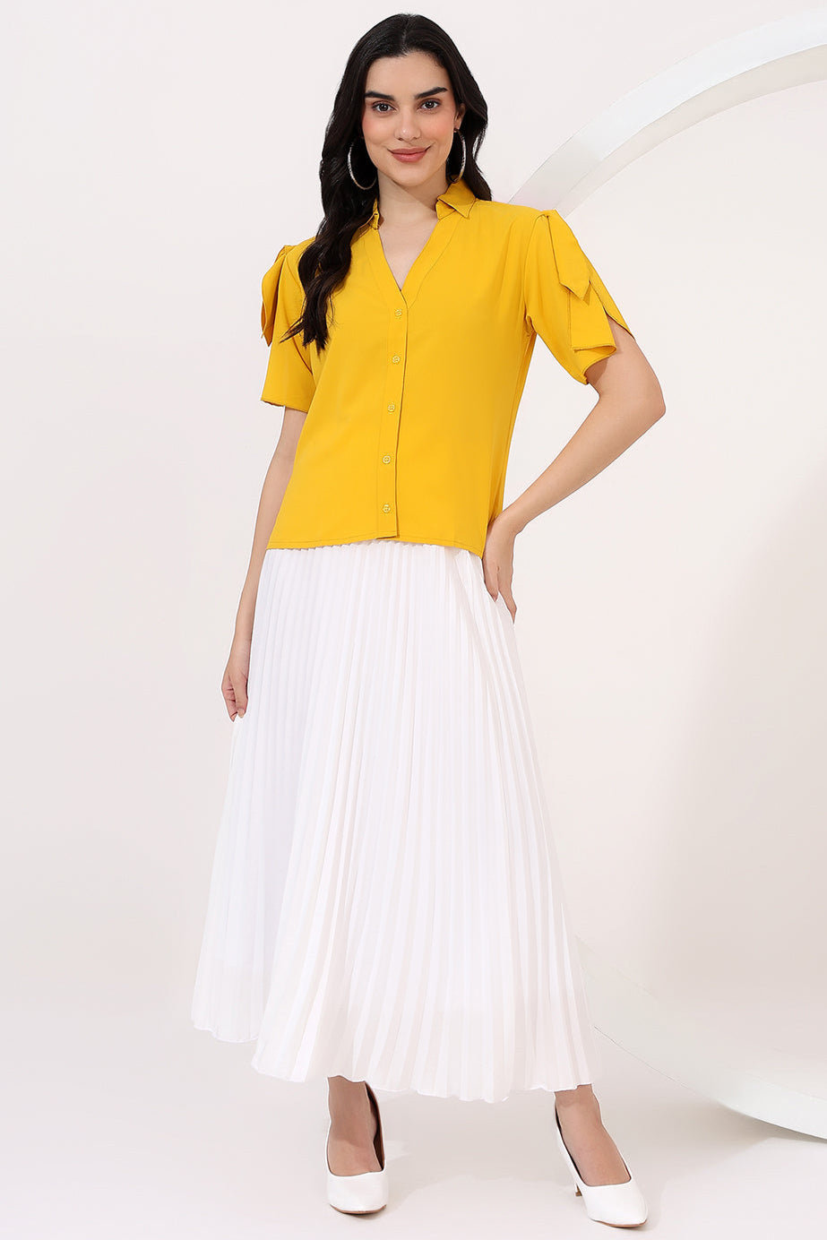 Woman wearing a yellow top and white skirt on a white background