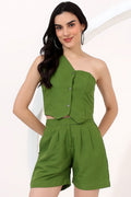 Woman wearing a green one-shoulder top and shorts set on a white background