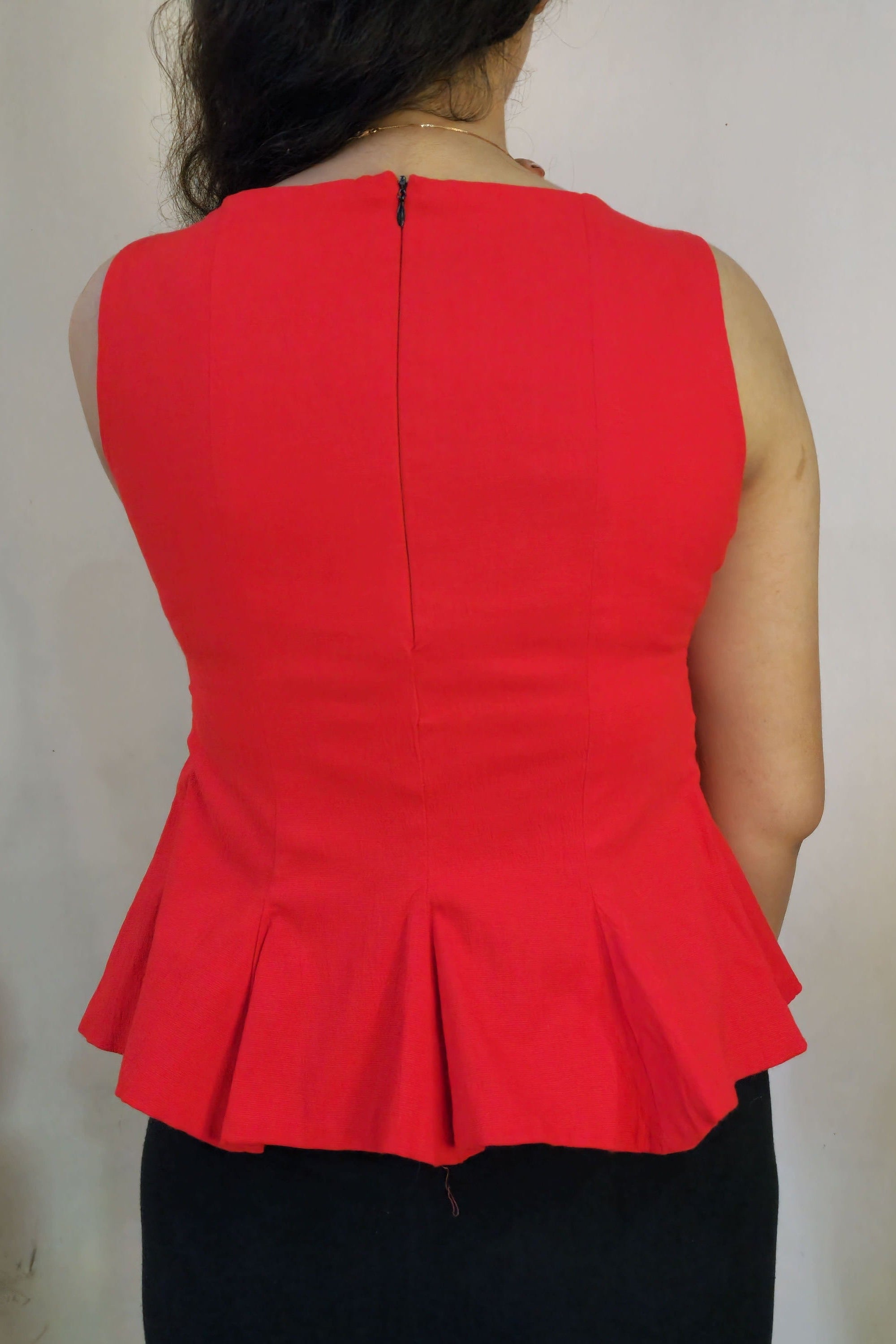 Red strapless dress with a pleated design on a plain background