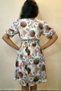 Woman wearing a floral dress with a neutral background