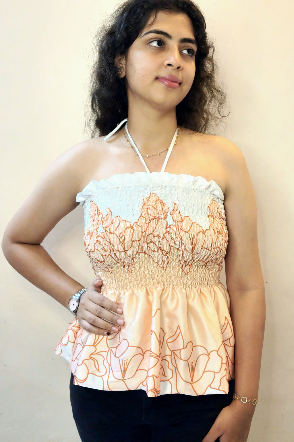 Woman wearing a floral top against a plain background