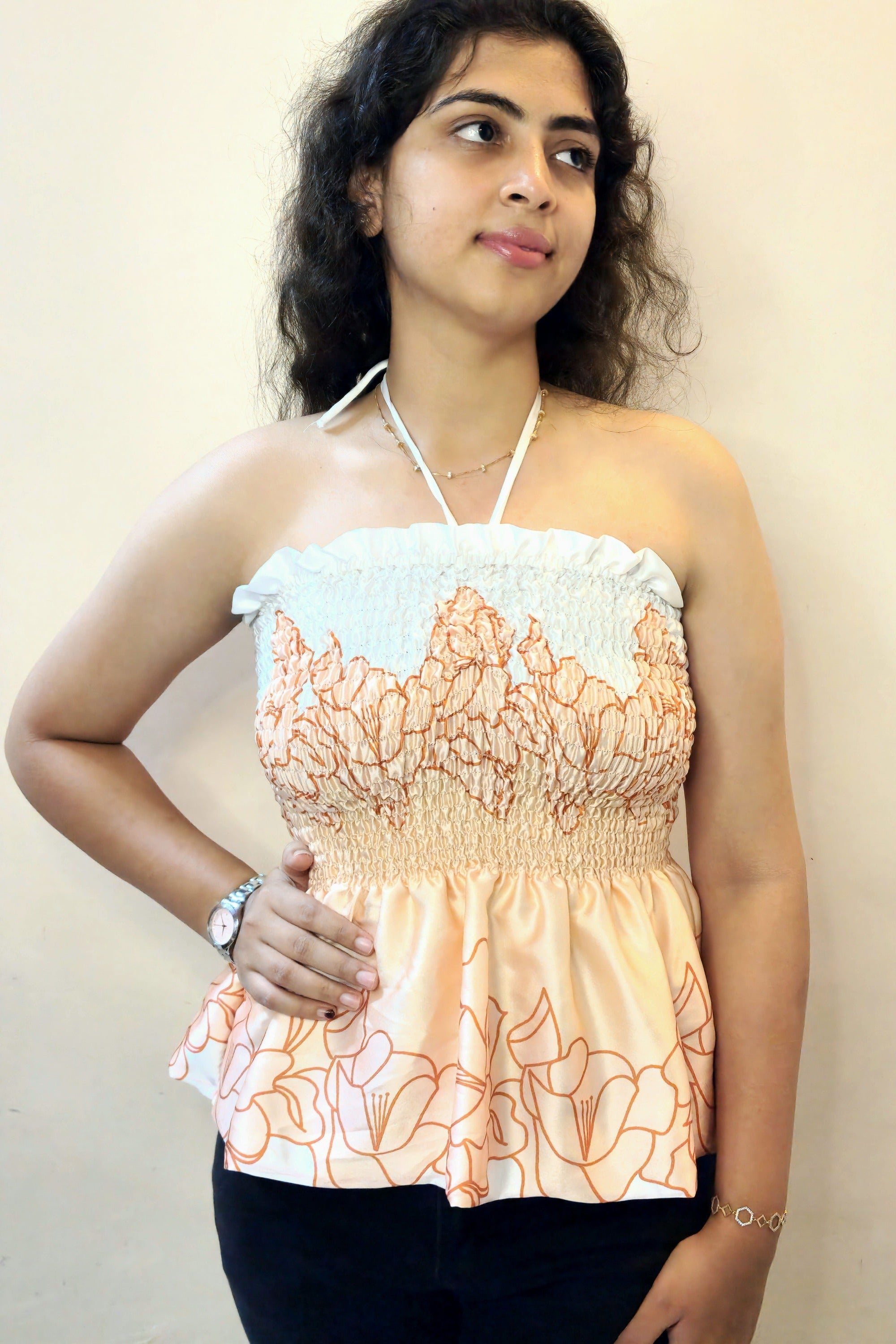 Woman wearing a floral top against a plain background