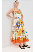 Woman wearing a colorful floral dress against a white background