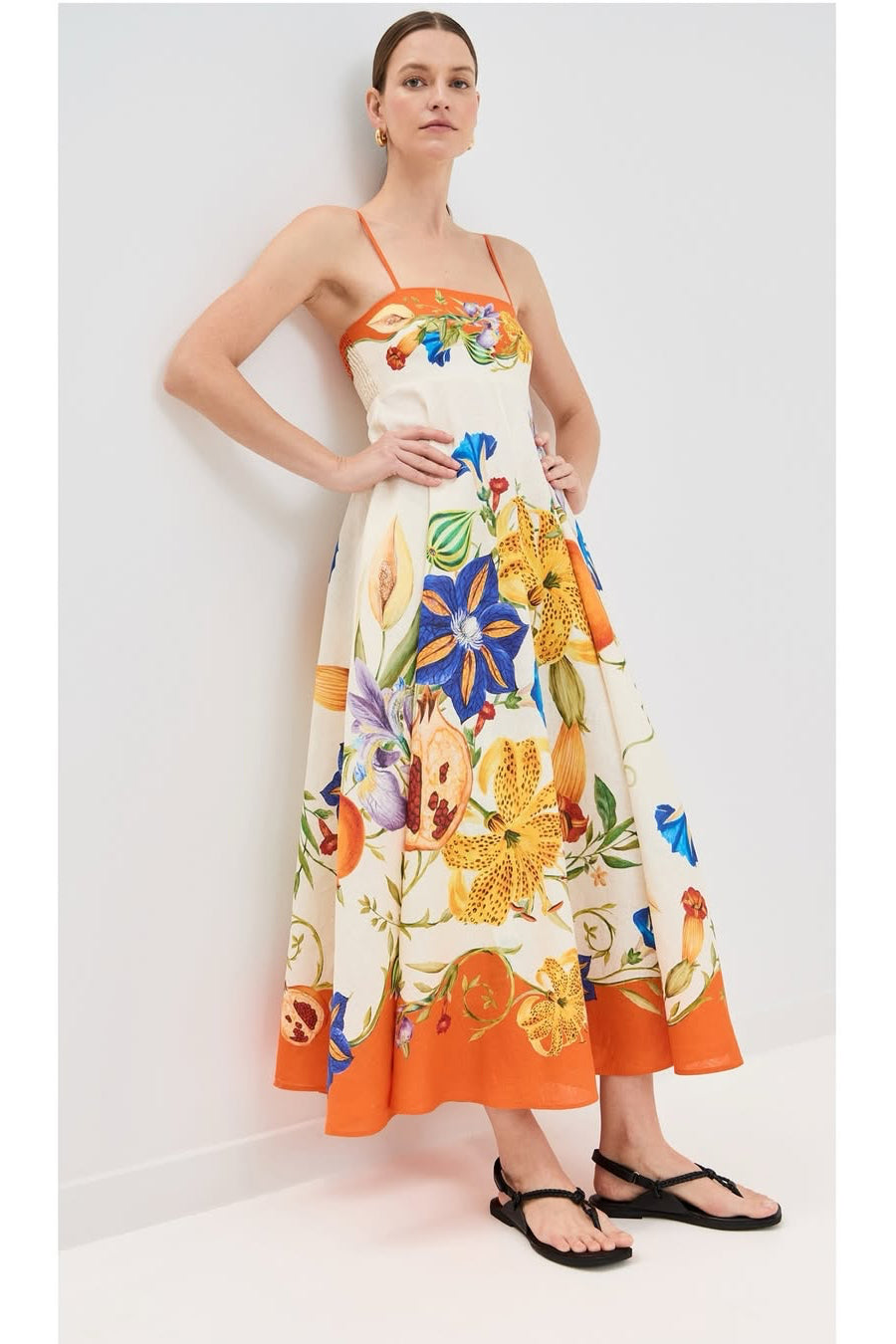 Woman wearing a colorful floral dress against a white background