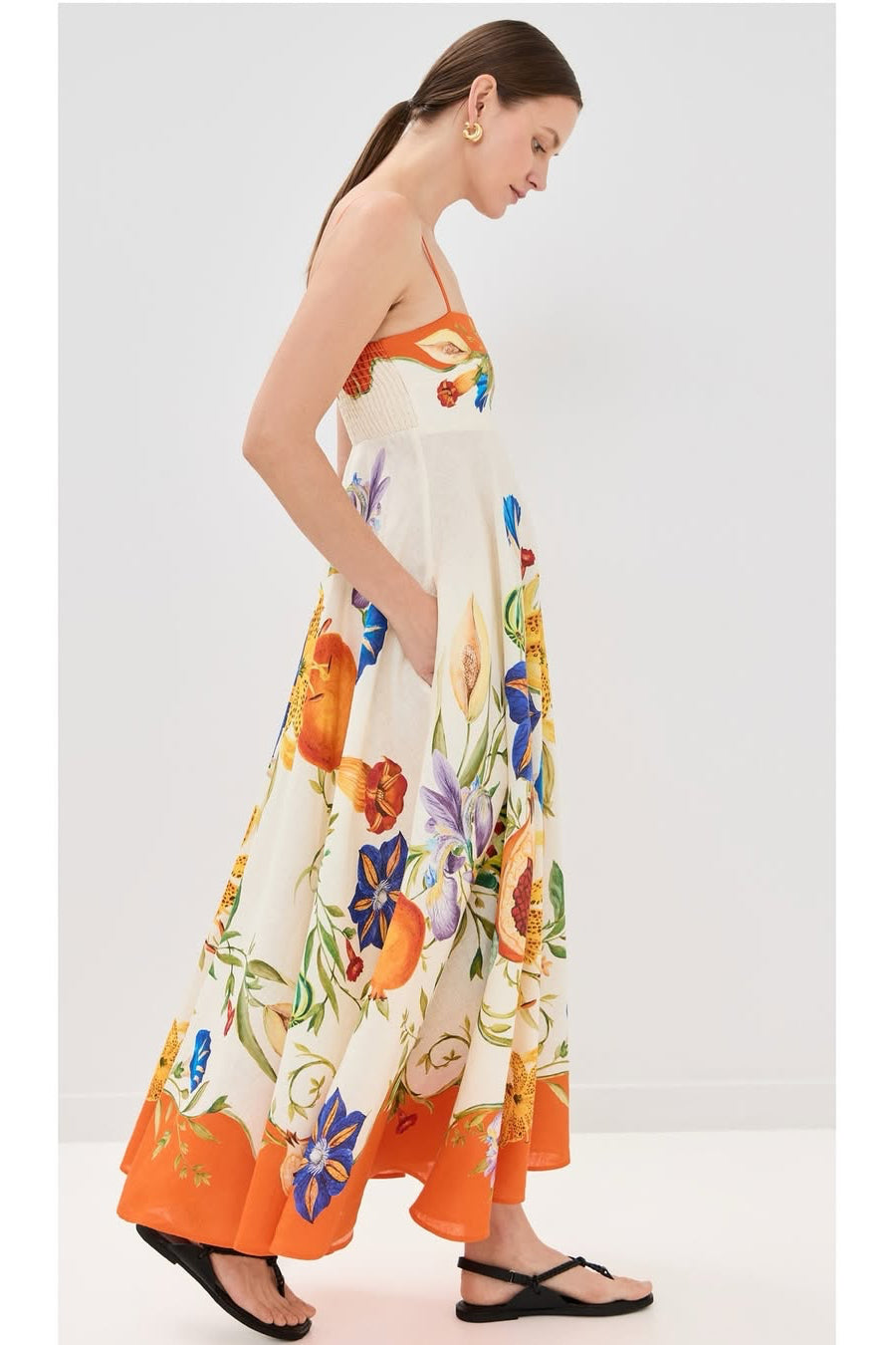 Woman wearing a colorful floral dress against a white background
