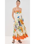 Woman wearing a floral dress with orange accents on a white background