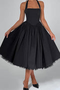 Black halter neck dress with a full skirt on a gray background
