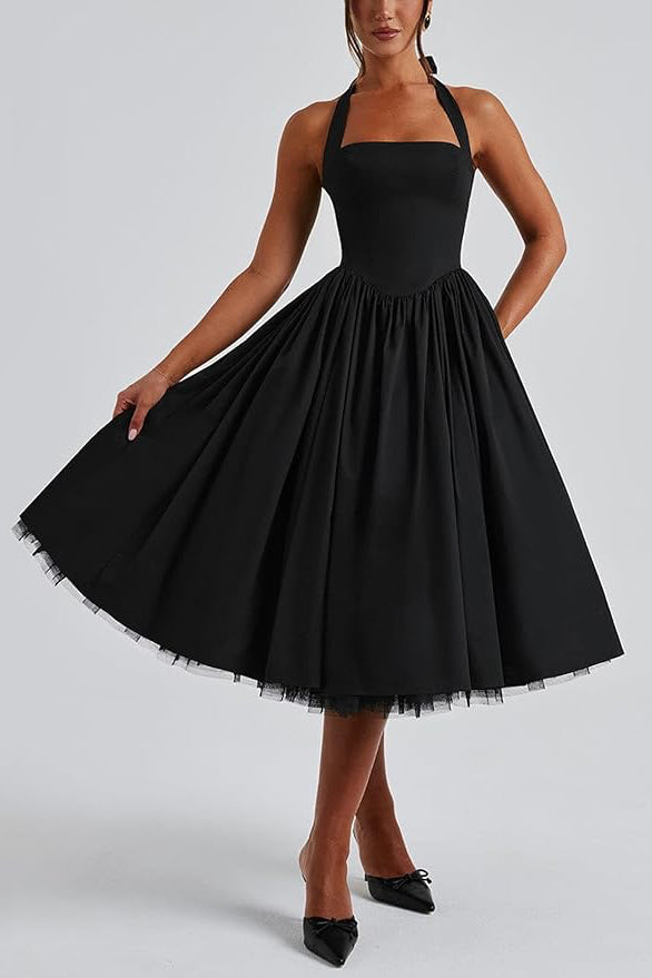 Black halter neck dress with a full skirt on a plain background
