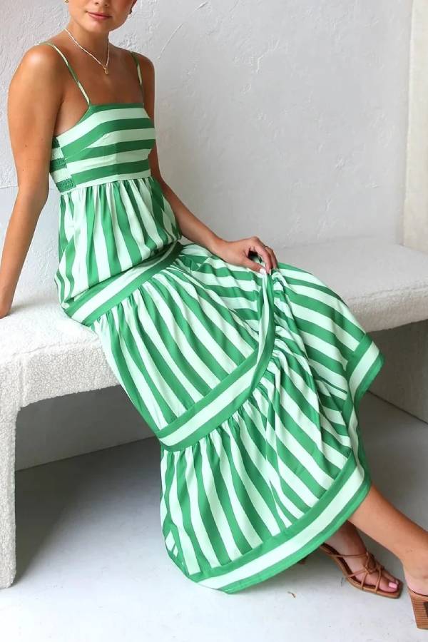 Green and white striped dress worn by a person on a white background