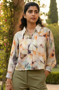 Woman wearing a colorful floral shirt with a blurred natural background