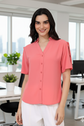 Woman wearing a pink blouse in an office setting