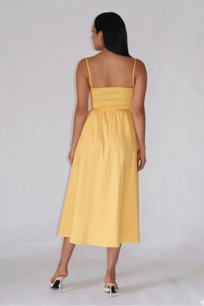 Woman wearing a yellow dress against a white background