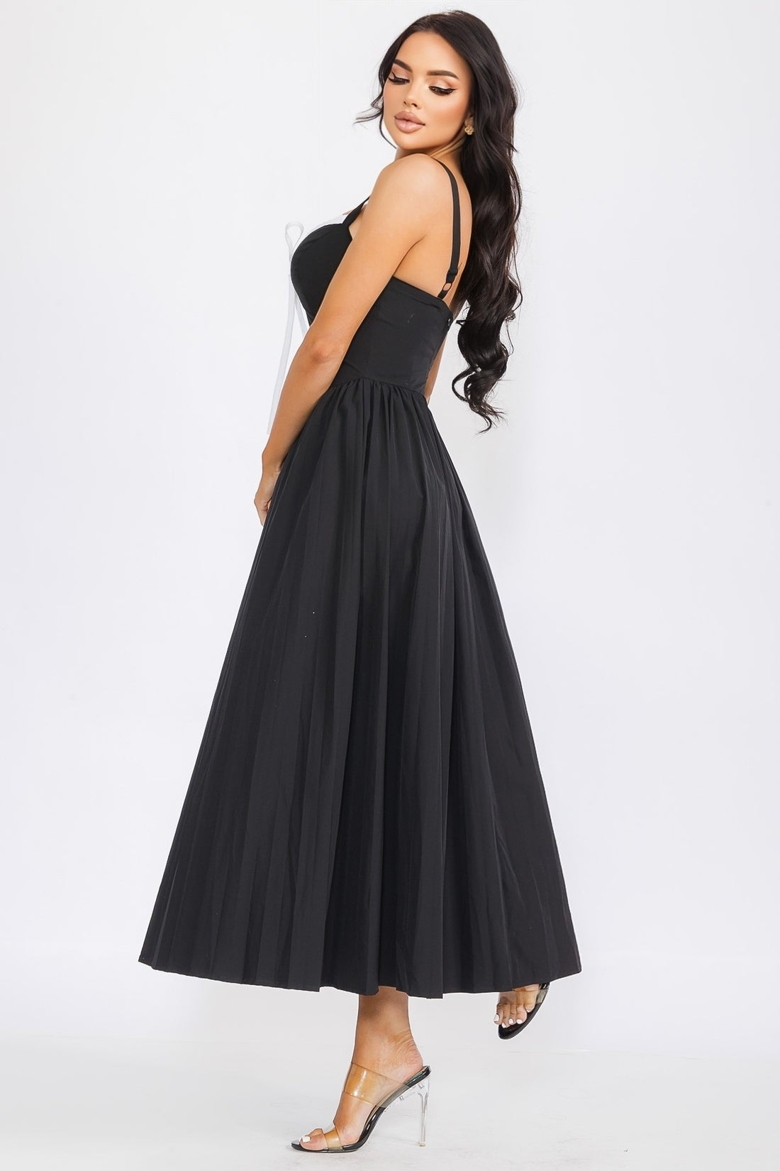 Woman wearing a black dress with a white ribbon on a white background