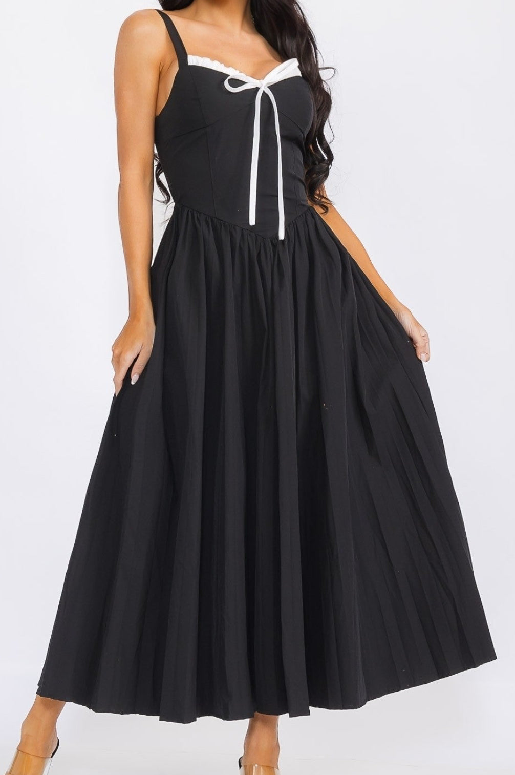 Woman wearing a black dress with a white ribbon on a white background