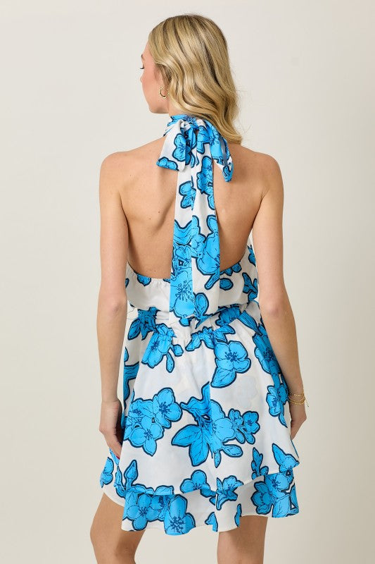 Woman wearing a blue and white floral dress in an indoor setting