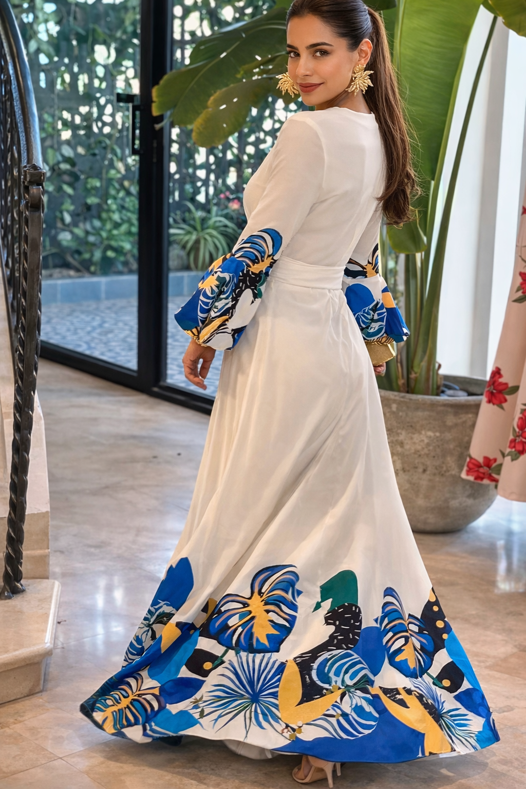 Woman wearing a long, elegant dress with colorful floral patterns indoors.