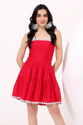 Woman wearing a red dress with white lace trim on a white background