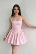Woman wearing a pink dress against a plain background