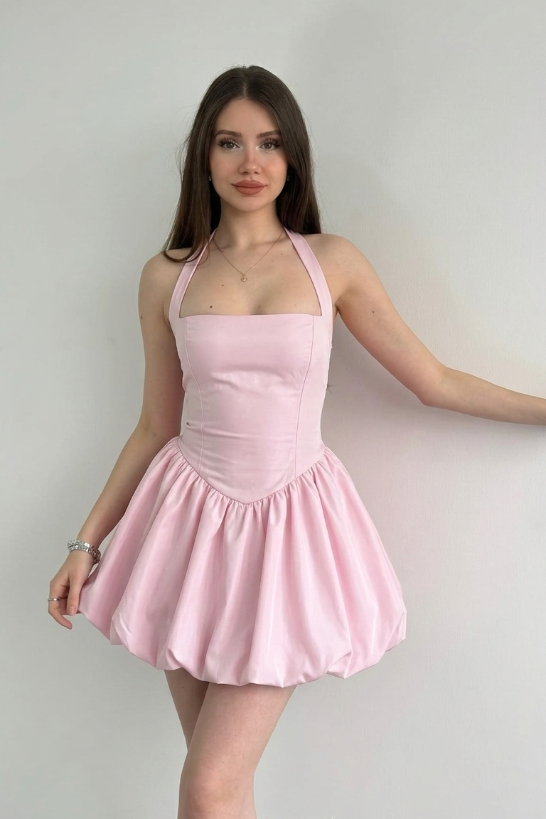 Woman wearing a pink dress against a plain background