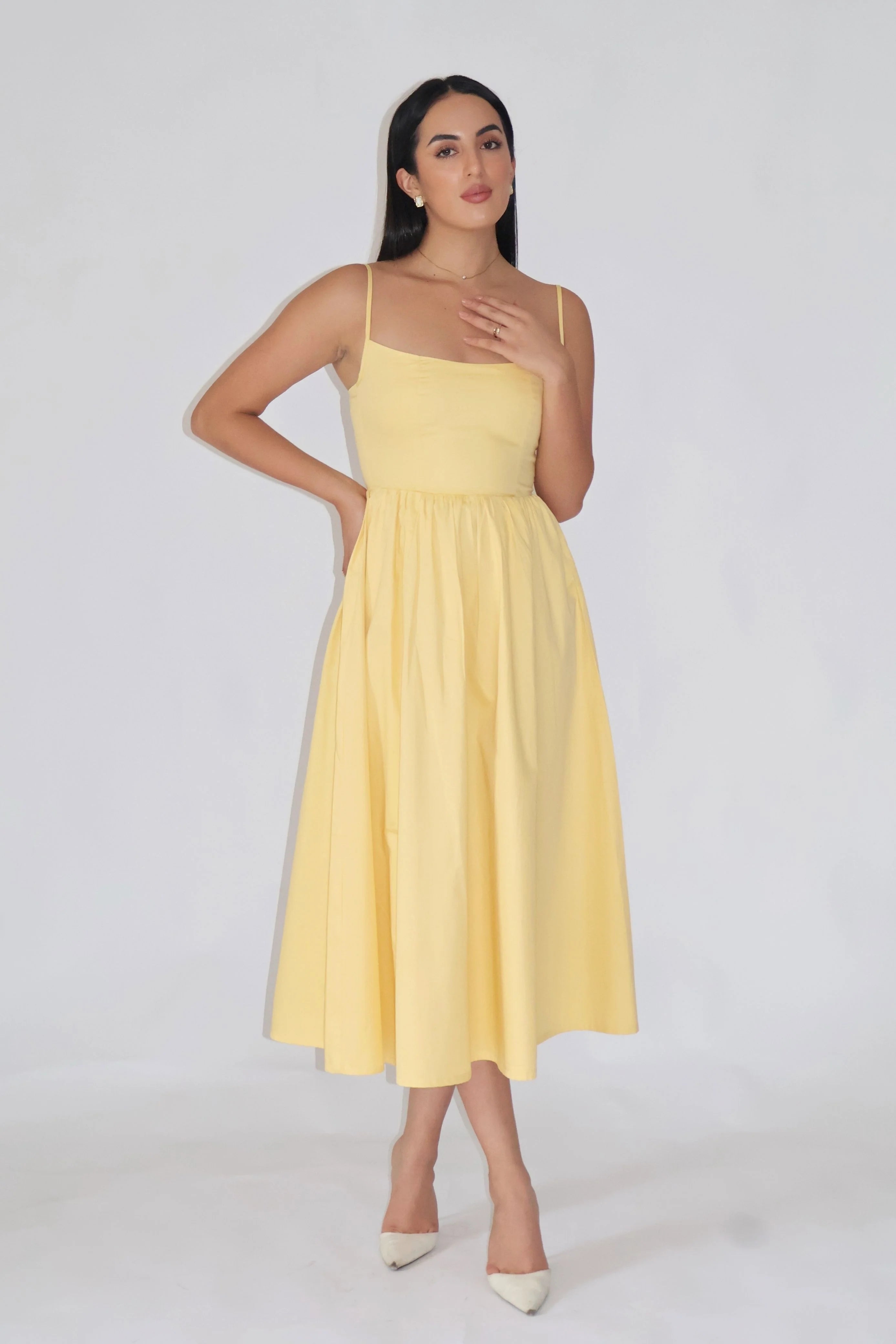Woman wearing a yellow dress against a white background